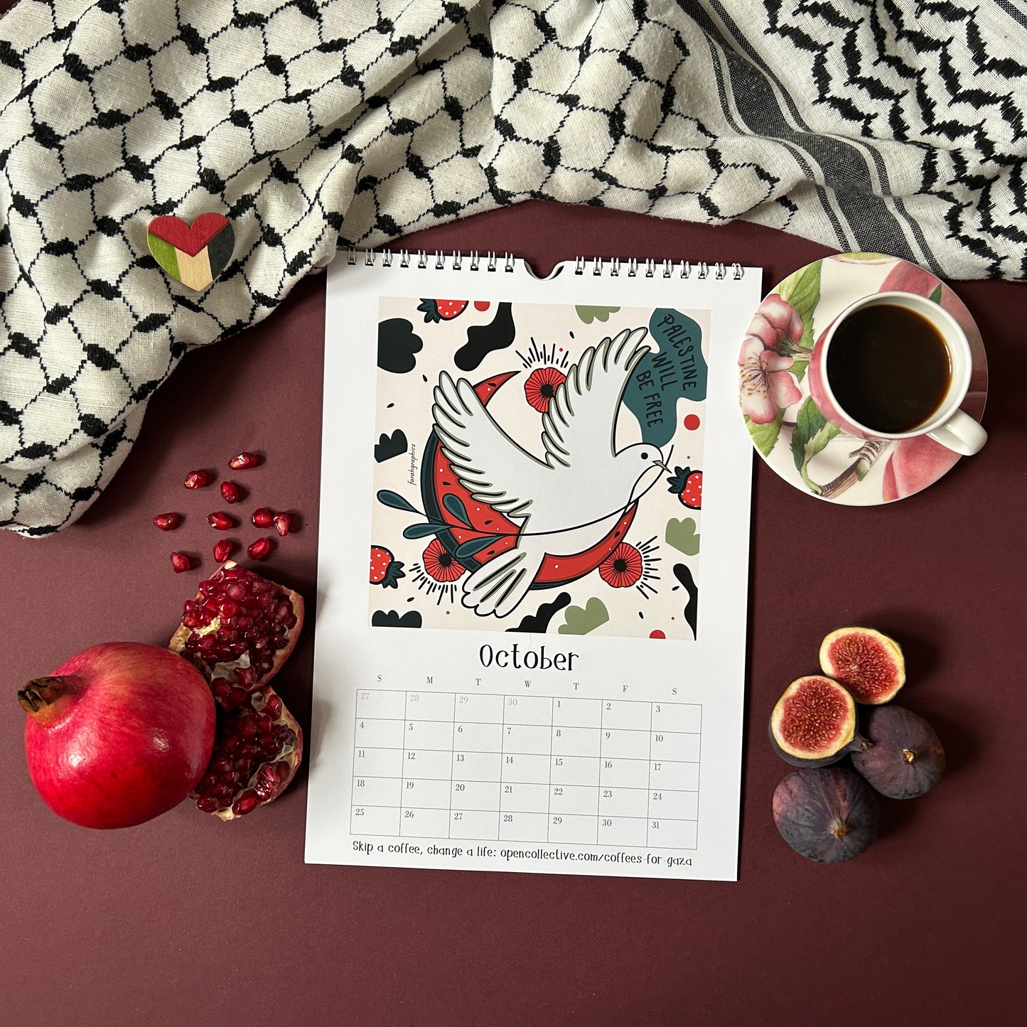 Calendar for October with a dove illustration, surrounded by pomegranate, figs, and a cup of coffee with a keffiyeh